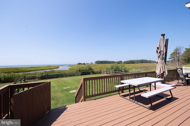 wooden terrace featuring a yard, a water view, and a rural view