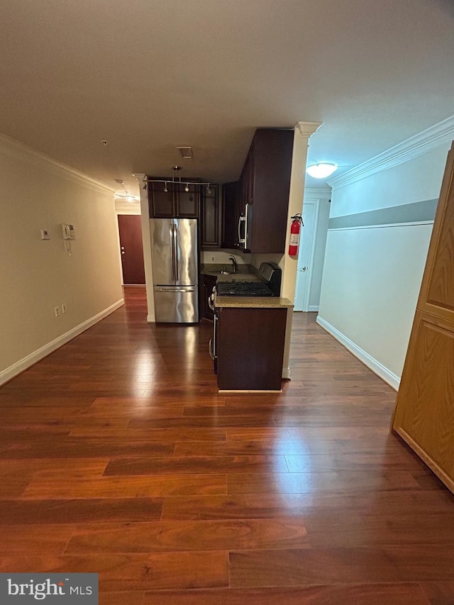 kitchen featuring dark wood-type flooring, sink, dark brown cabinets, ornamental molding, and stainless steel appliances