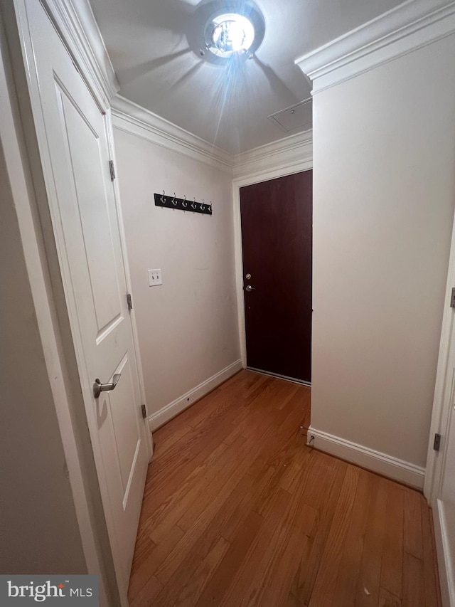 hall with light hardwood / wood-style flooring and ornamental molding