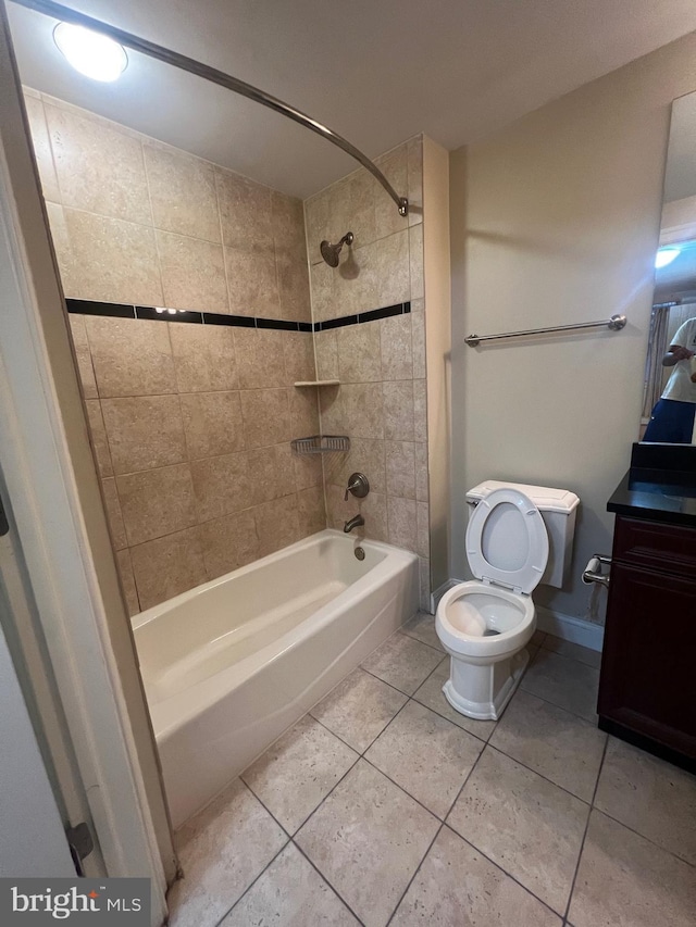 full bathroom featuring tiled shower / bath, vanity, tile patterned floors, and toilet