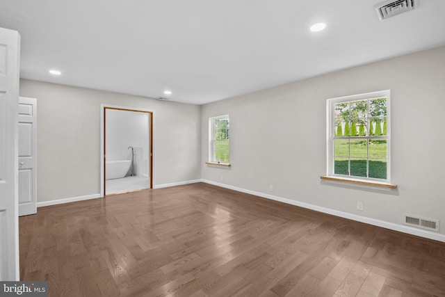 unfurnished bedroom featuring parquet floors and ensuite bath