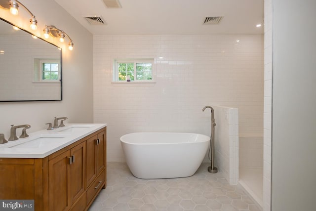 bathroom with vanity, tile walls, independent shower and bath, and tile patterned floors