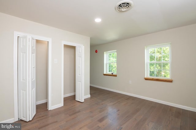 unfurnished bedroom with dark wood-type flooring