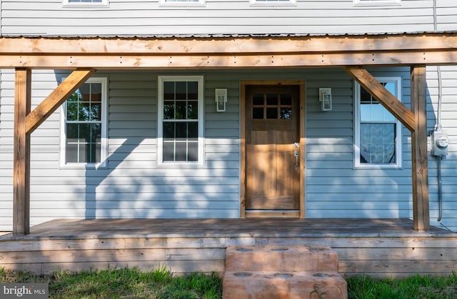 view of exterior entry featuring a wooden deck