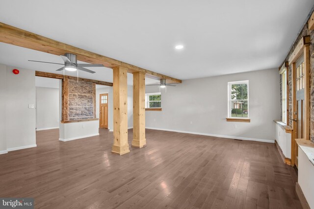 unfurnished living room with beamed ceiling, ornate columns, ceiling fan, and dark hardwood / wood-style floors