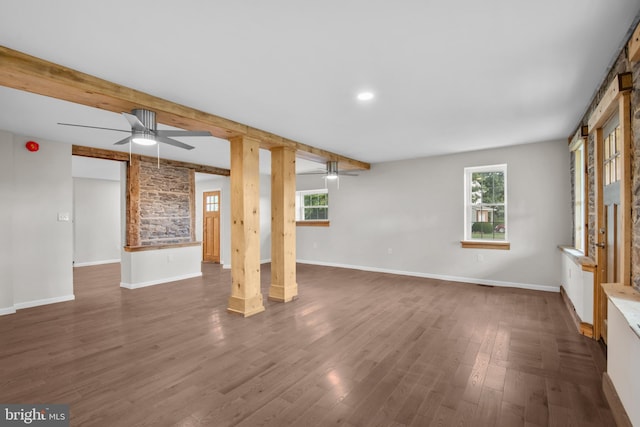 unfurnished living room with dark wood-style flooring, beamed ceiling, baseboards, and ceiling fan