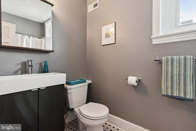 bathroom with vanity, tile patterned flooring, and toilet