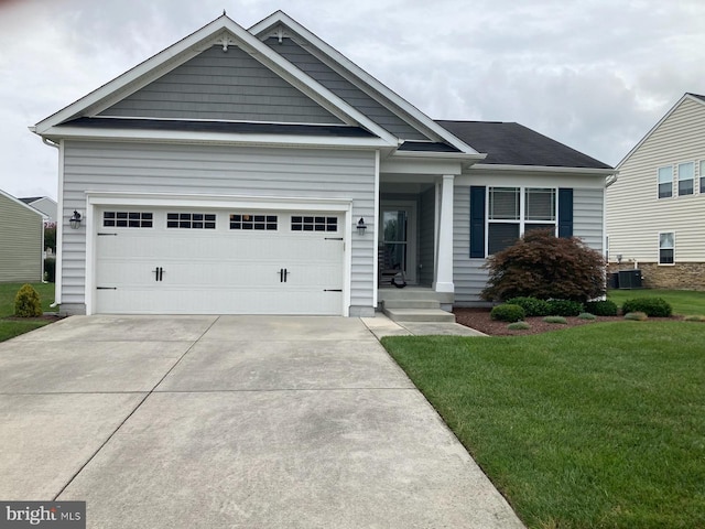 view of front of house featuring a front lawn, cooling unit, and a garage