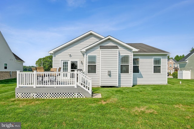 back of house featuring a deck and a lawn