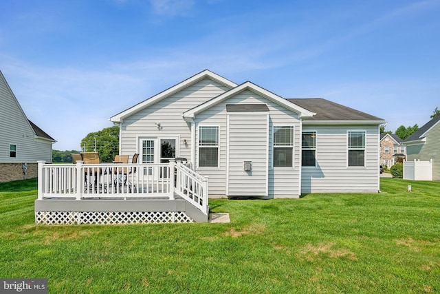 rear view of property featuring a wooden deck and a yard