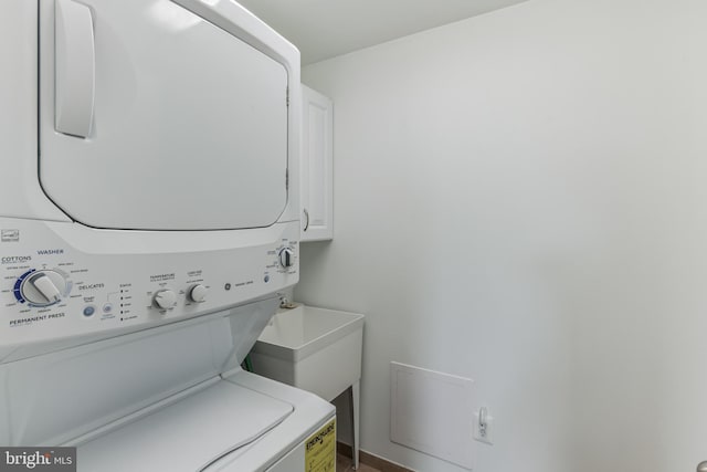 clothes washing area featuring stacked washer and clothes dryer