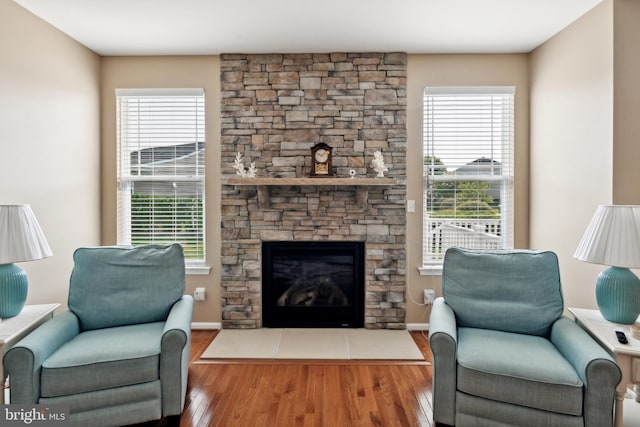 living room featuring hardwood / wood-style floors and a stone fireplace