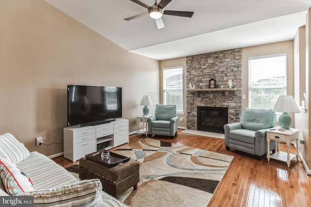 living room featuring ceiling fan, a fireplace, hardwood / wood-style flooring, and lofted ceiling