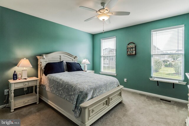 carpeted bedroom featuring ceiling fan and multiple windows