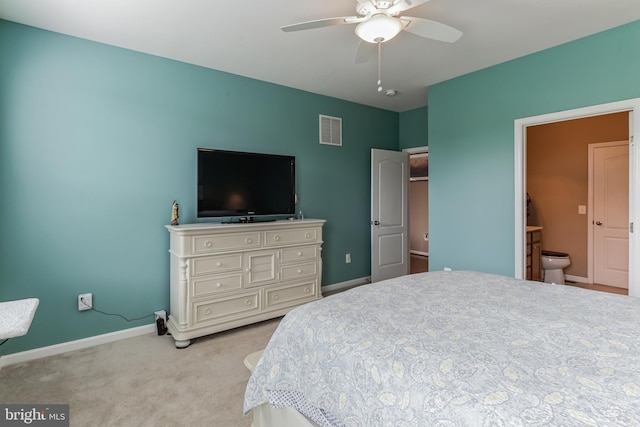 carpeted bedroom featuring ceiling fan and ensuite bath