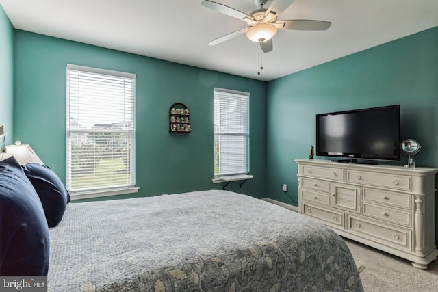 carpeted bedroom featuring ceiling fan and multiple windows