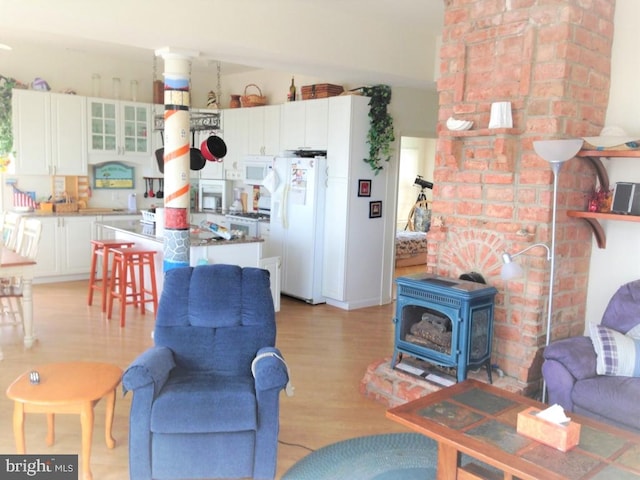 living room with a wood stove and light wood-type flooring