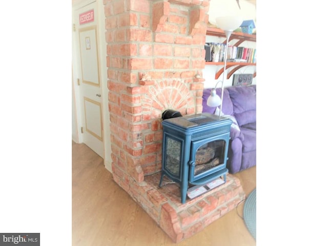 interior details with wood-type flooring and a wood stove