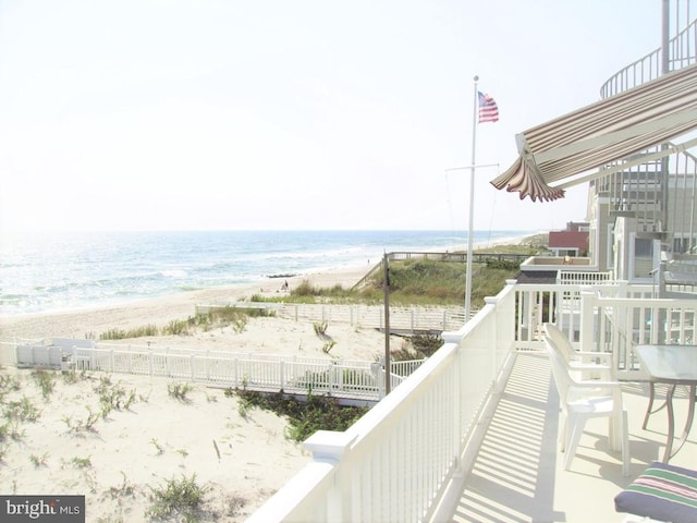 balcony featuring a water view and a beach view