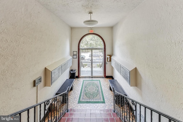 entryway featuring mail boxes and a textured ceiling