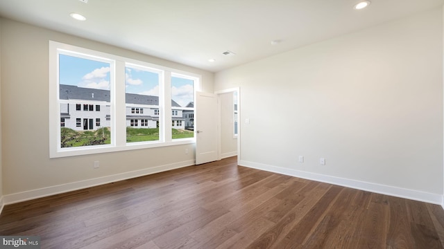 unfurnished room featuring dark wood-style floors, recessed lighting, visible vents, and baseboards