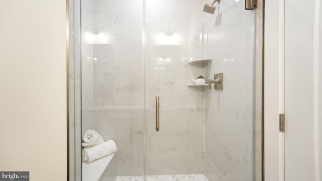 bathroom featuring a marble finish shower