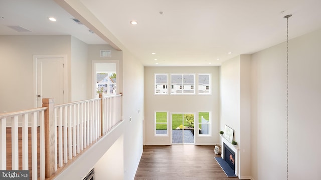 corridor with plenty of natural light, visible vents, dark wood finished floors, and recessed lighting