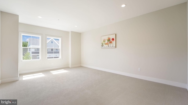 empty room with light carpet, baseboards, and recessed lighting