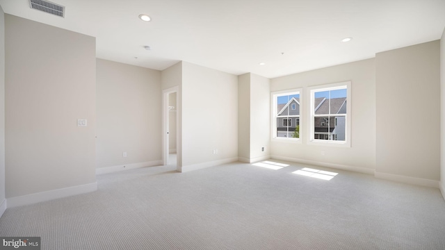 spare room featuring light carpet, baseboards, visible vents, and recessed lighting