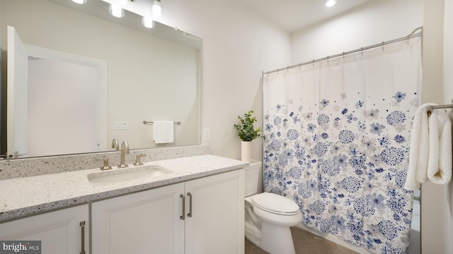 bathroom with toilet, tile patterned flooring, and vanity