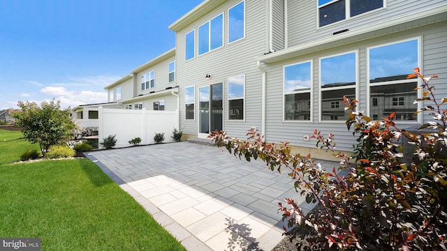 rear view of house with a yard, a patio area, and fence