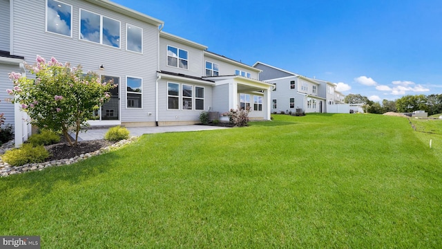 rear view of house with a yard and a patio