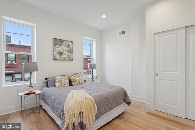 bedroom with light wood-type flooring and a closet