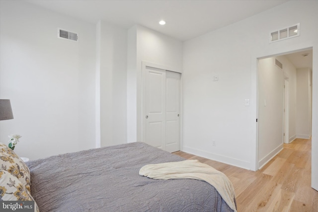 bedroom with light hardwood / wood-style flooring and a closet