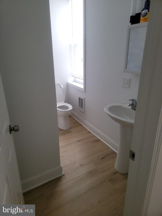 bathroom with toilet and hardwood / wood-style floors