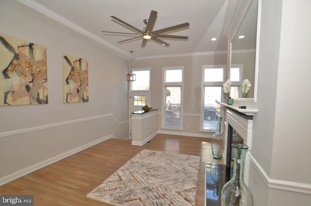 foyer featuring crown molding, ceiling fan, and light wood-type flooring