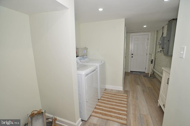 laundry area featuring independent washer and dryer and light hardwood / wood-style flooring