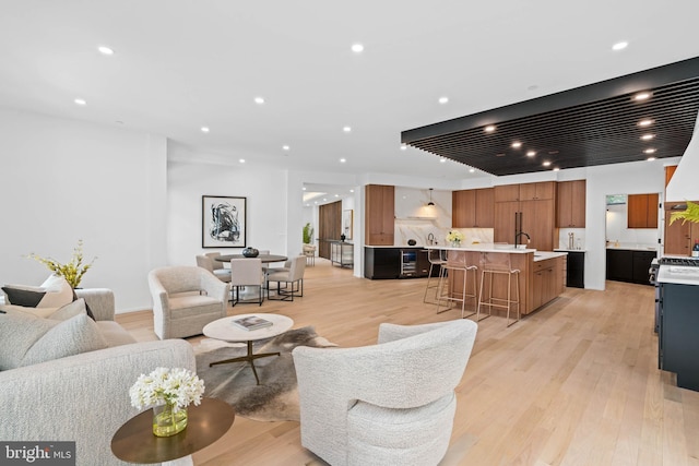 living room featuring sink and light hardwood / wood-style flooring