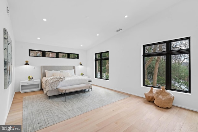 bedroom featuring light wood-type flooring and lofted ceiling