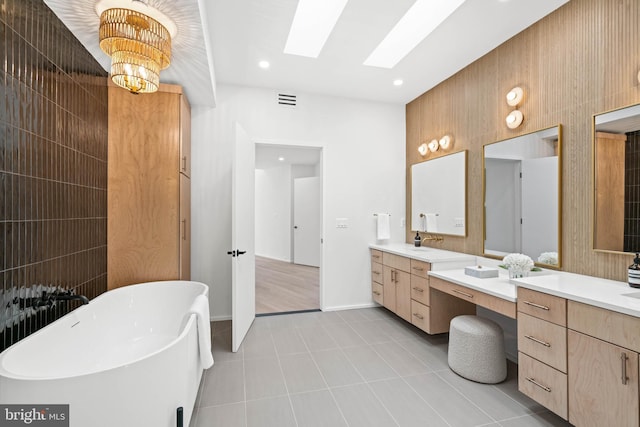 bathroom with a bathing tub, a skylight, tile patterned floors, radiator heating unit, and vanity