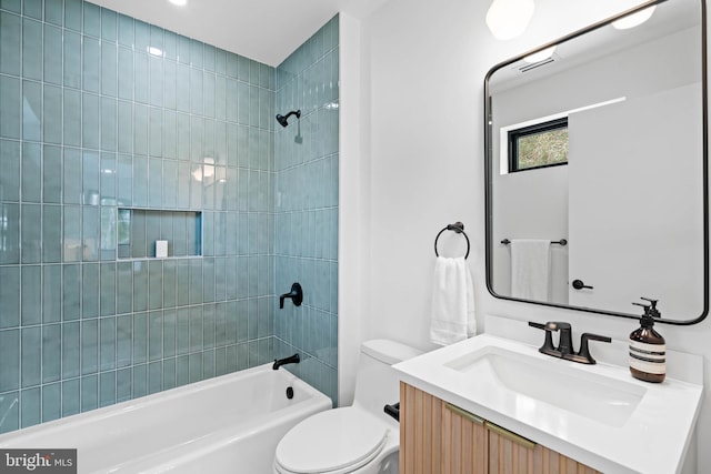 full bathroom featuring tiled shower / bath, vanity, and toilet