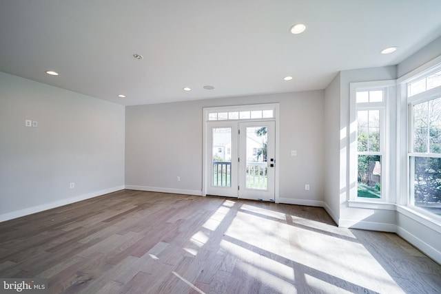 interior space featuring baseboards, light wood finished floors, and recessed lighting