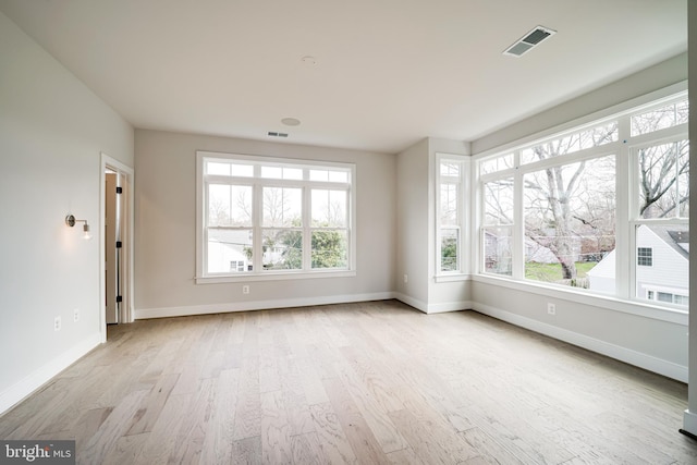 unfurnished room with baseboards, visible vents, and light wood-style floors