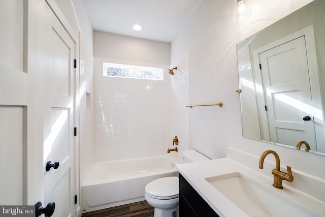 full bathroom featuring toilet, vanity, wood finished floors, and washtub / shower combination