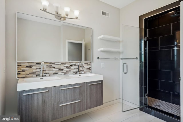 bathroom with tile patterned floors, vanity, an enclosed shower, and decorative backsplash