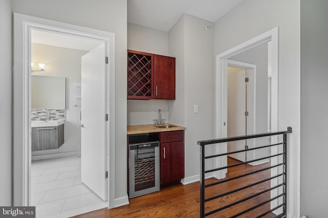 bar with tasteful backsplash, wood-type flooring, sink, and wine cooler