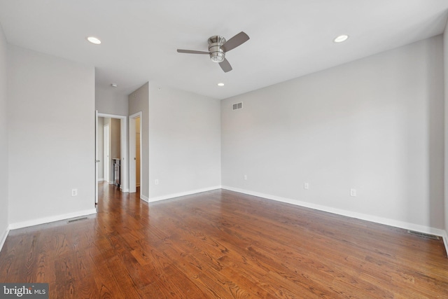 spare room with dark hardwood / wood-style flooring and ceiling fan