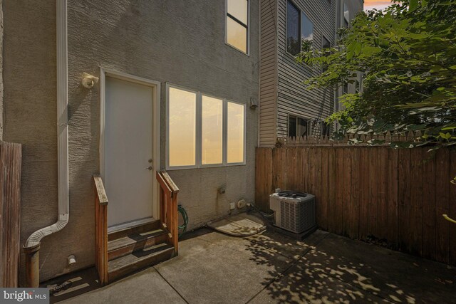 patio terrace at dusk with central air condition unit