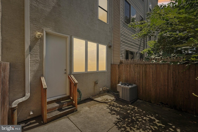view of home's exterior featuring a patio area, stucco siding, central AC, entry steps, and fence