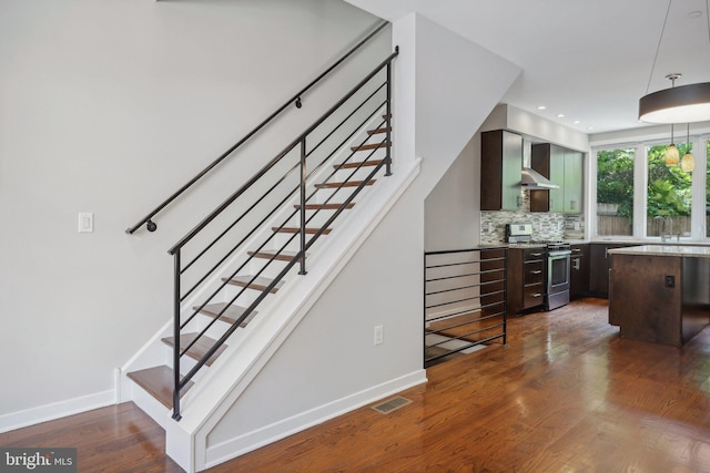 bar featuring dark hardwood / wood-style flooring, stainless steel range oven, dark brown cabinets, and backsplash